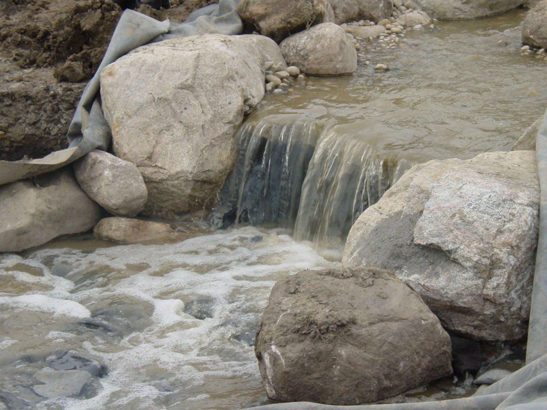 A small waterfall is surrounded by large rocks