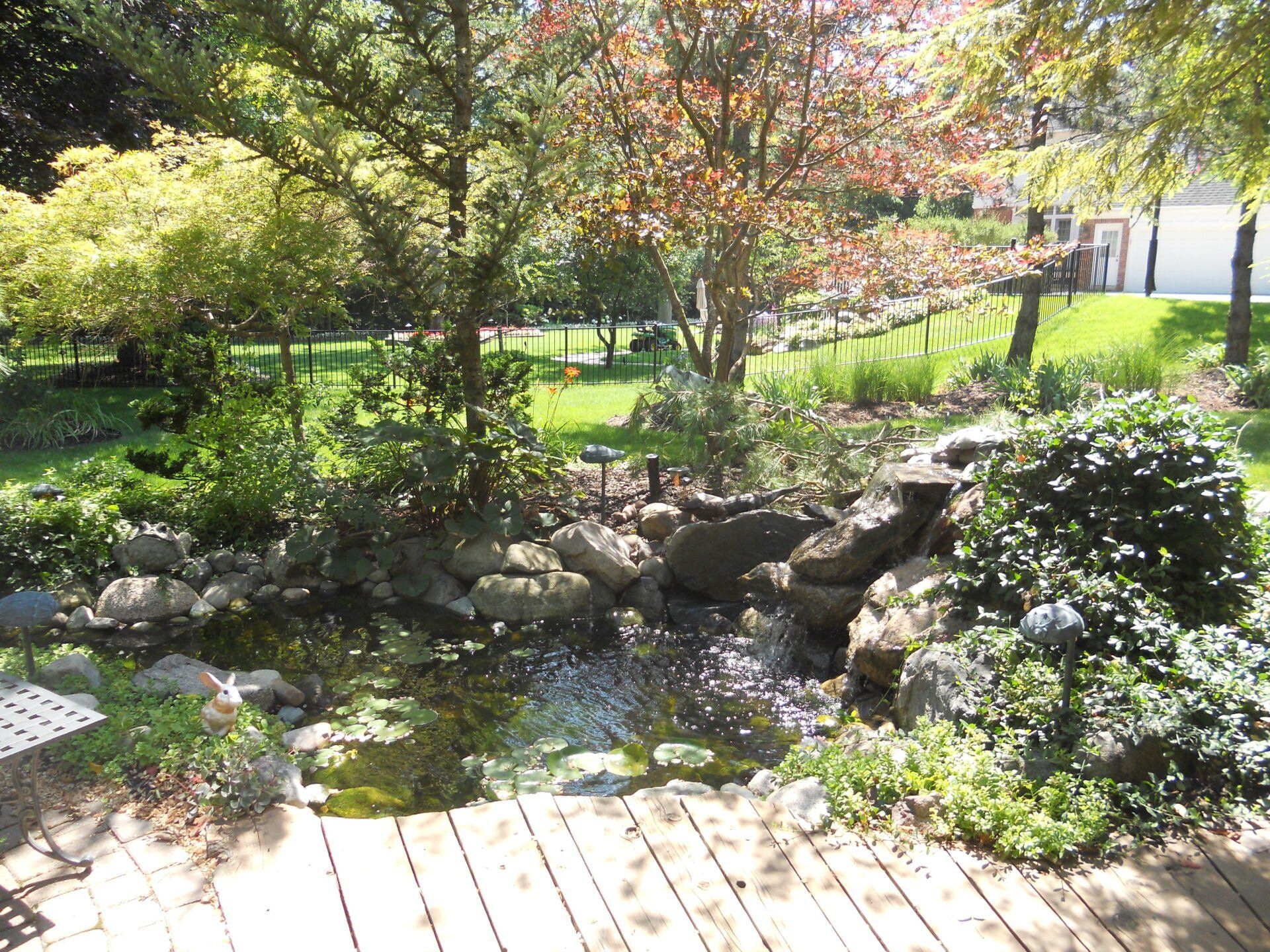 A wooden bridge over a pond in a garden