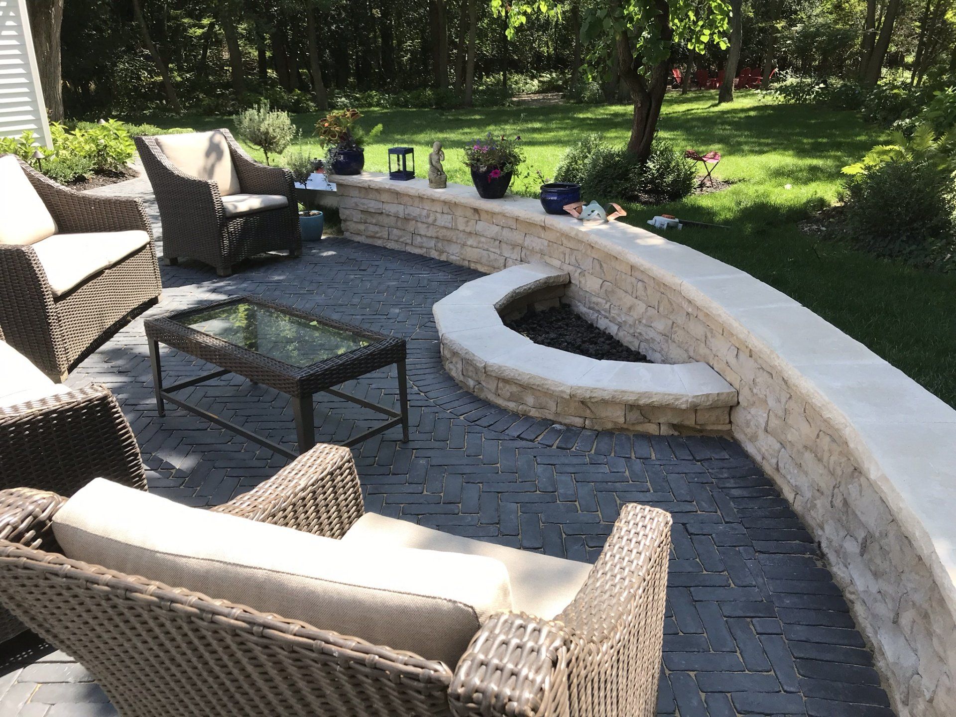 A patio with wicker furniture and a fire pit
