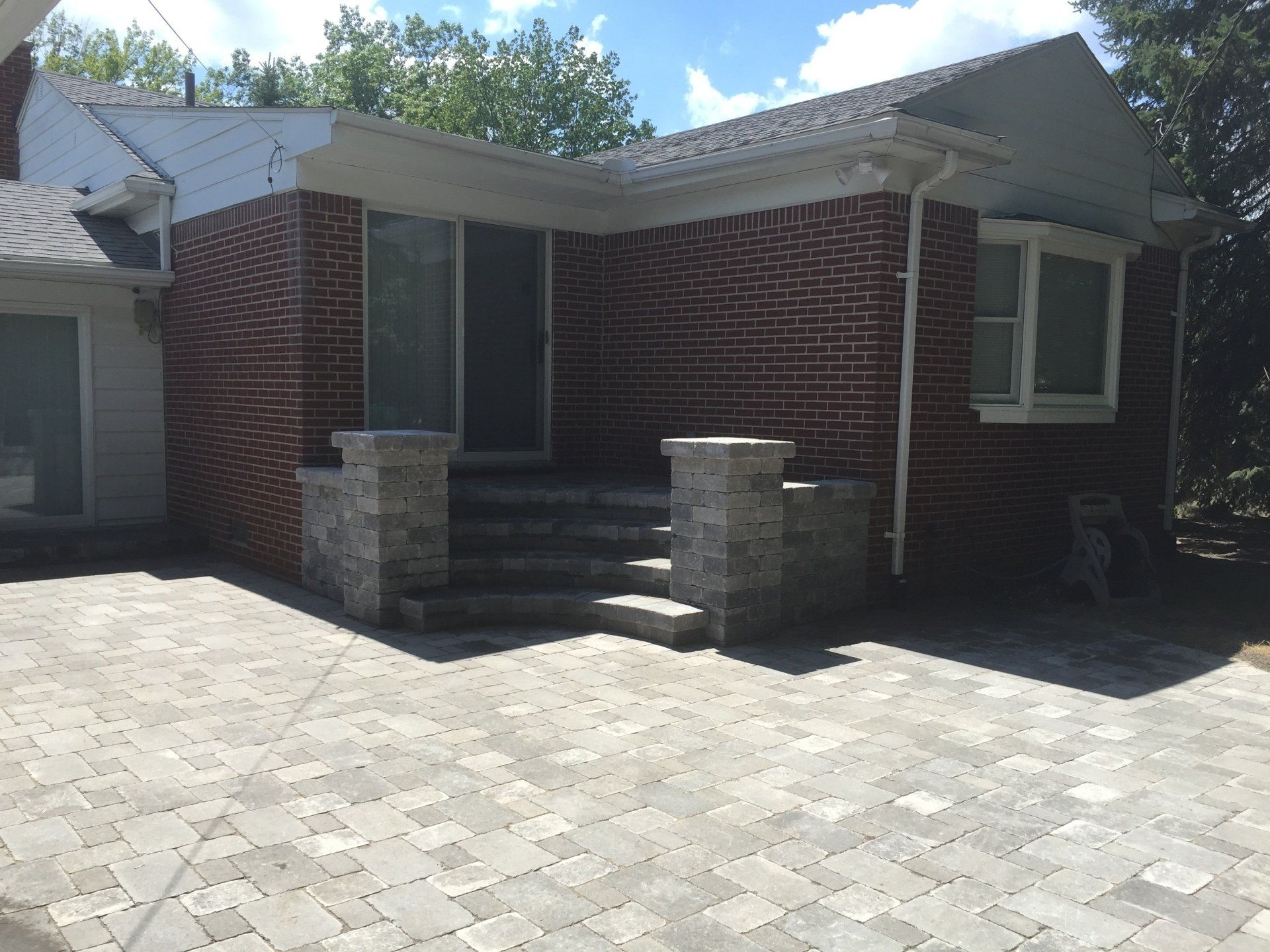 A brick house with a brick driveway in front of it