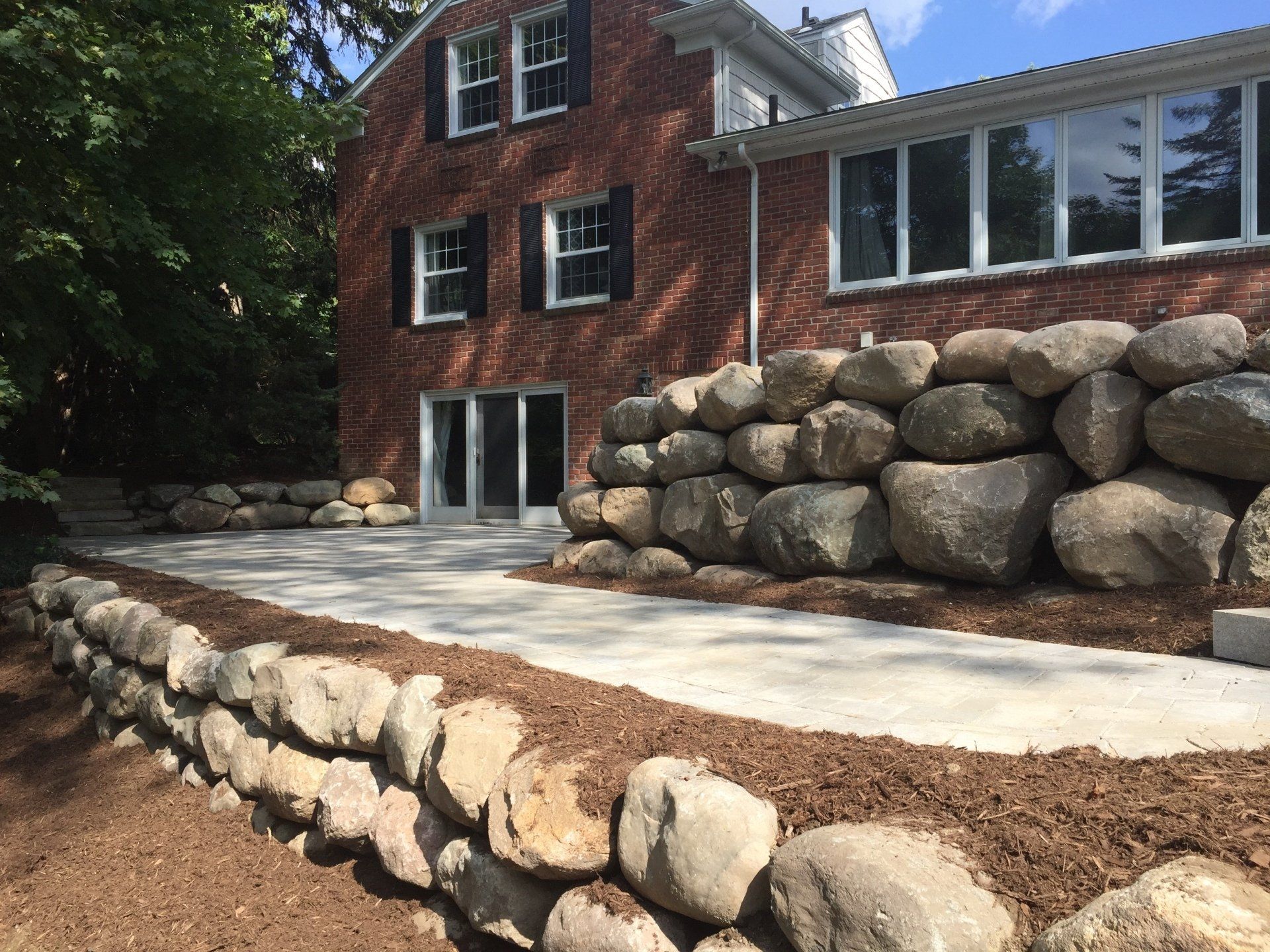 A brick house with a stone wall in front of it