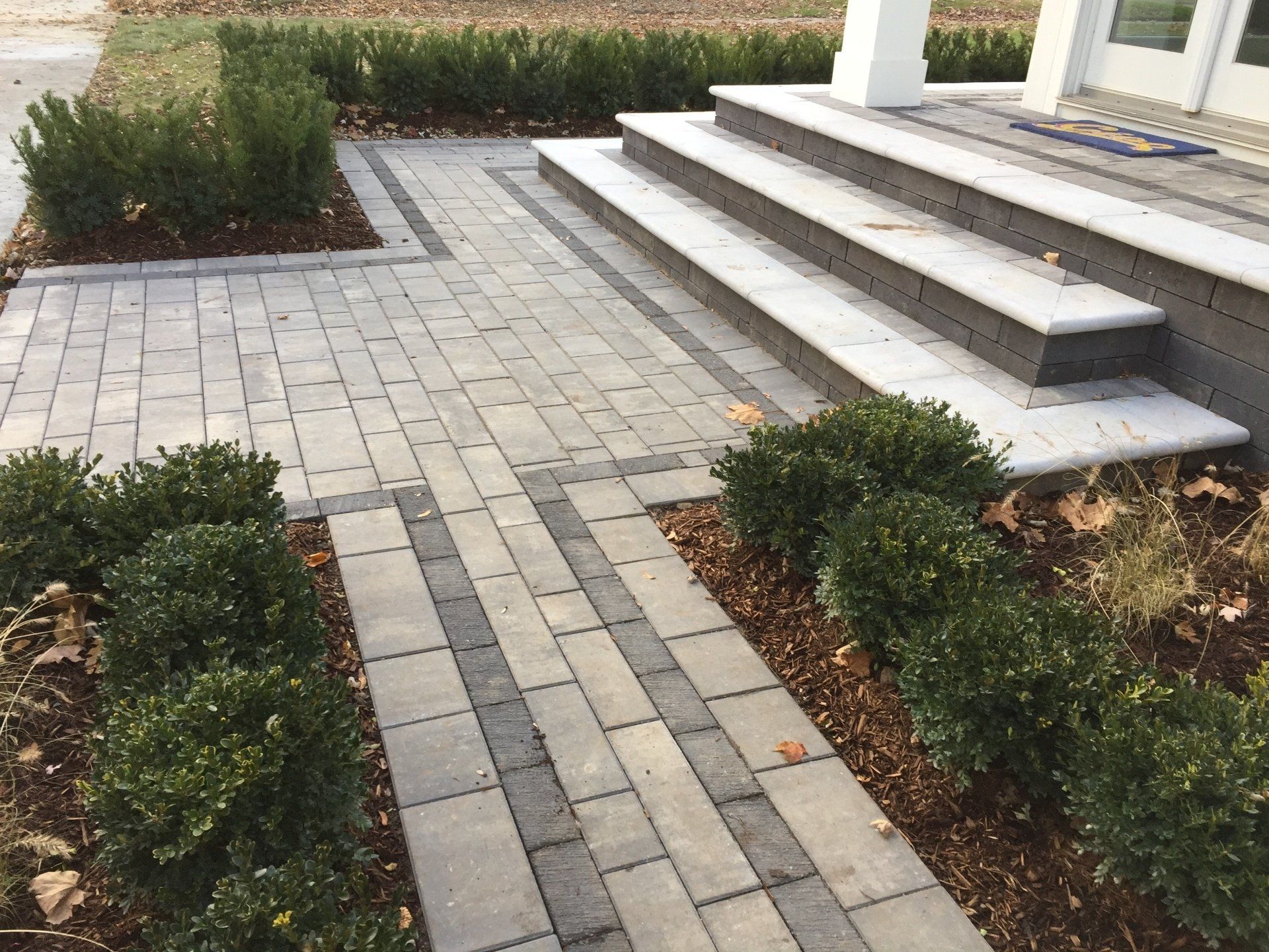 A brick walkway with steps leading up to a house
