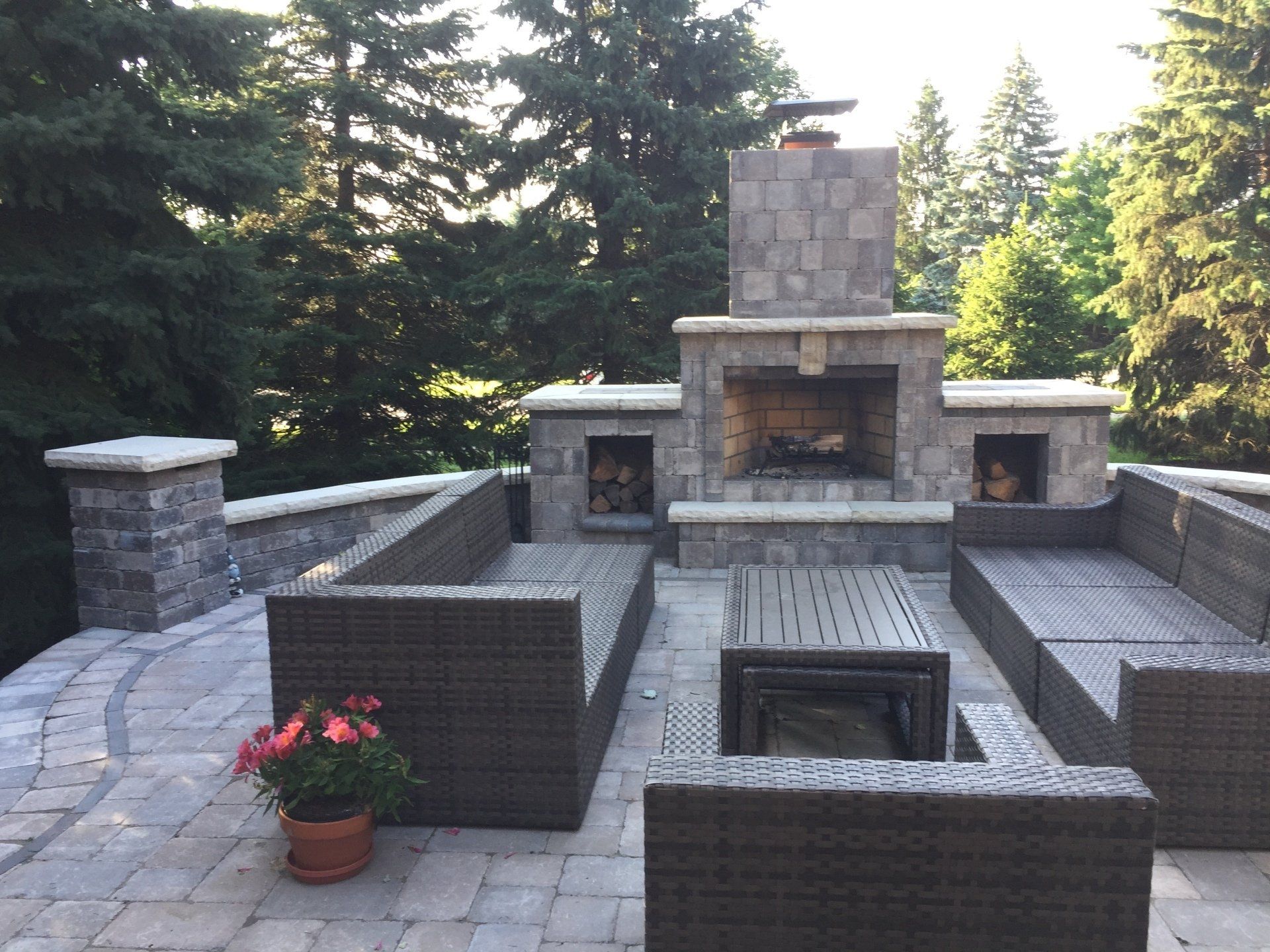 A patio with wicker furniture and a fireplace