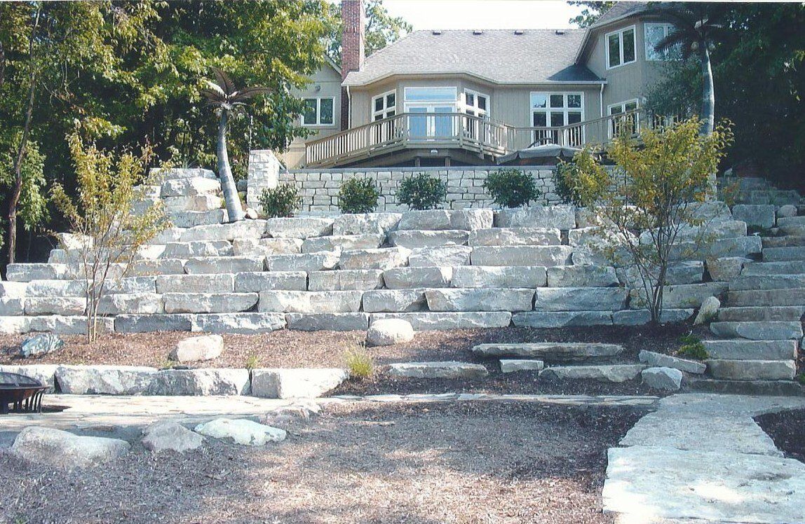 A large house sits on a hill with stairs leading up to it