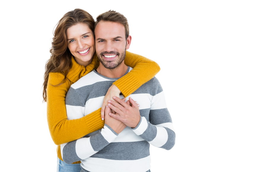 A woman is hugging a man in a striped sweater.