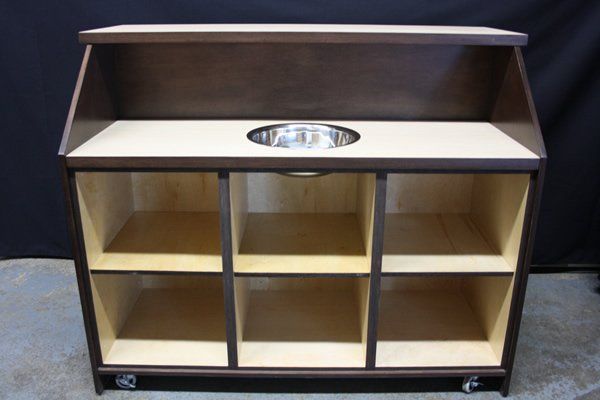 Brown open shelving unit with six compartments and a top display shelf with an oval cutout handle