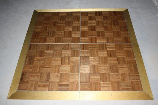 Wooden parquet floor panel with a gold border on a light background