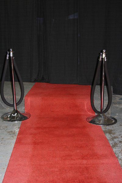 Red carpet walkway with black velvet stanchions and a black backdrop