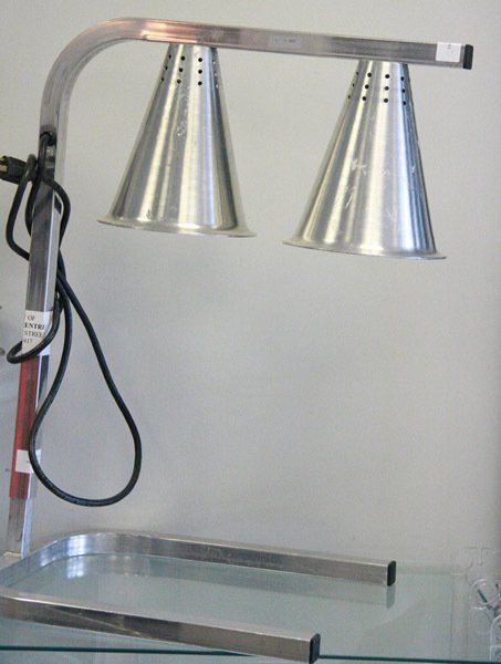 Two metal cone heat lamps above a stainless steel tray on a wall-mounted fixture