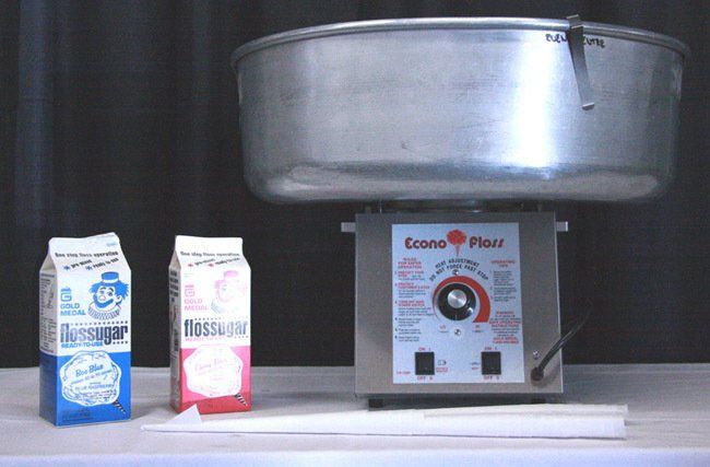 Food scale with metal bowl and two cartons on a counter.