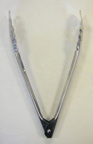 Silver metal V-shaped kitchen tongs with black handles on a plain background