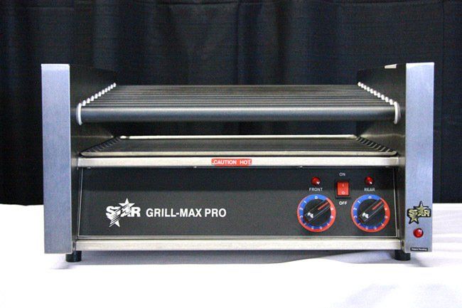 Compact stainless steel grill with two control knobs and a top warming rack on a black background