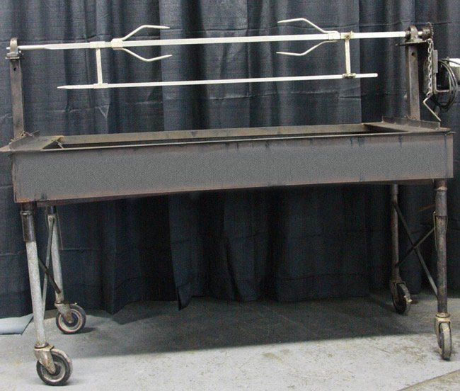 Metal utility cart with long tongs and a dark curtain backdrop