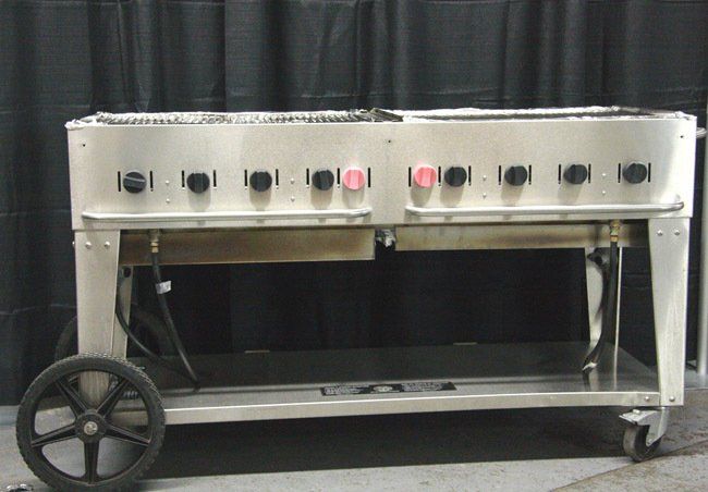 Portable stainless steel cart with multiple knobs and shelves, on wheels, in a workshop setting