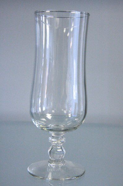 Clear glass goblet with a flared rim and stem on a light gray background