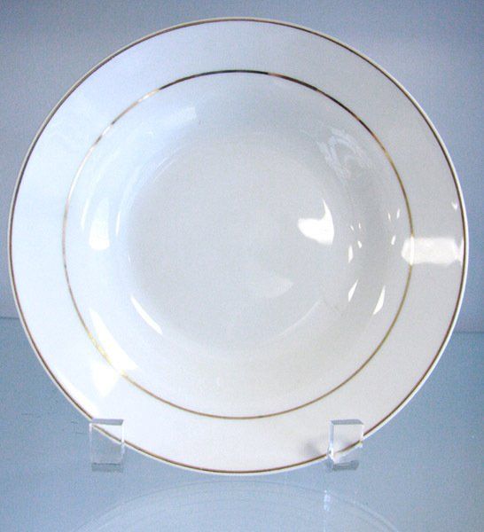 White porcelain plate with a gold rim on a display stand against a light blue background