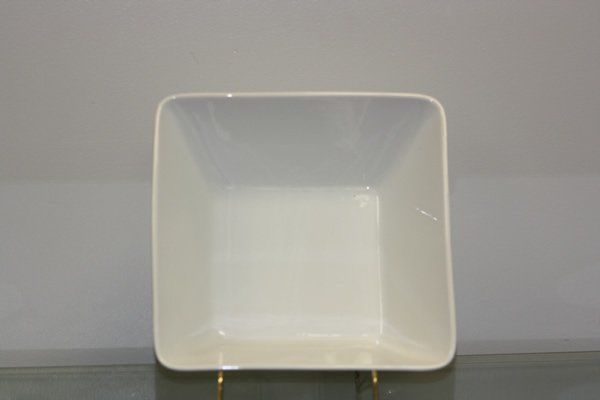 White square ceramic bowl centered on a plain gray background.