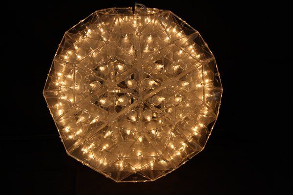 Golden circular decorative light fixture glowing against a black background