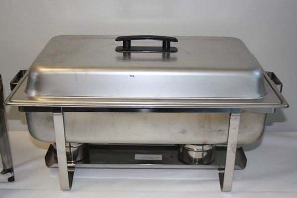 Stainless steel chafing dish with lid on a serving stand with burner beneath.