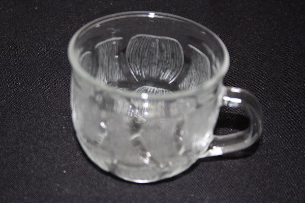 Clear glass mug with handle on a dark surface