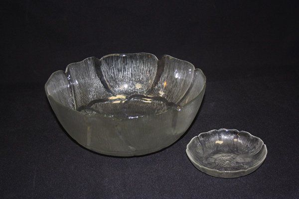 Two clear glass bowls on a black background, one large and one small