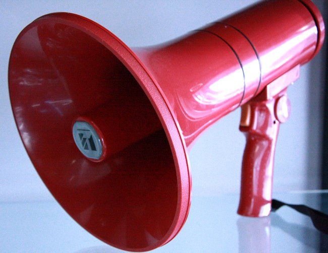 Red megaphone on a white surface against a light background