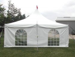 White outdoor event tent with peaked roof and arched windows on grass
