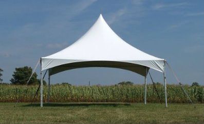 White canopy tent on a grassy field under a blue sky.