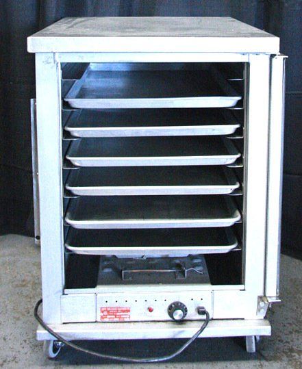 White metal drying cabinet with open front and stacked trays on casters
