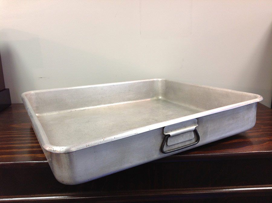 Empty rectangular aluminum baking pan on a dark wooden table
