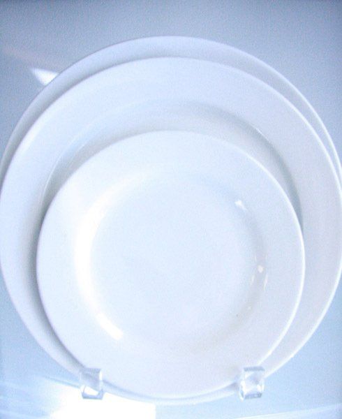 Stacked white plates on a blue surface