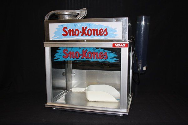 Sno-Kones snow cone machine with metal cabinet and clear bin on a black background