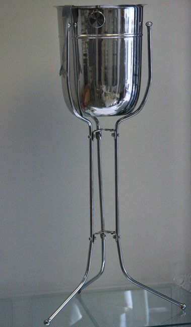 Silver trophy cup with a long stem and three-legged base on a plain background