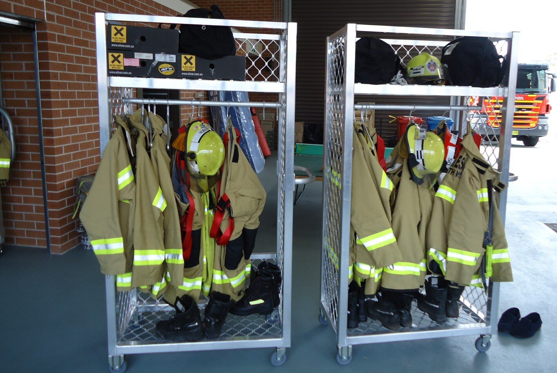 Two carts filled with firefighter 's uniforms and helmets.