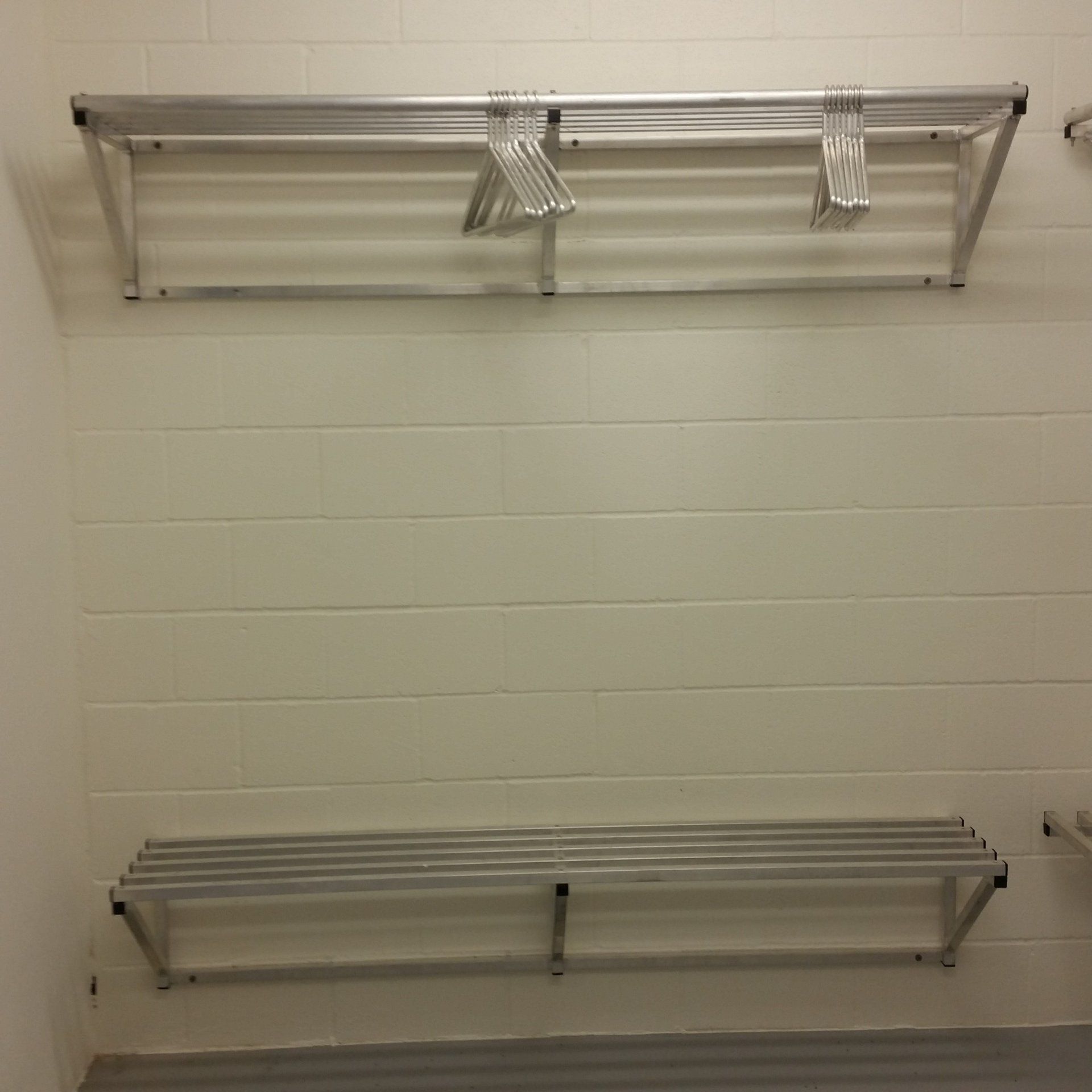 A closet with two shelves and clothes hanging on them