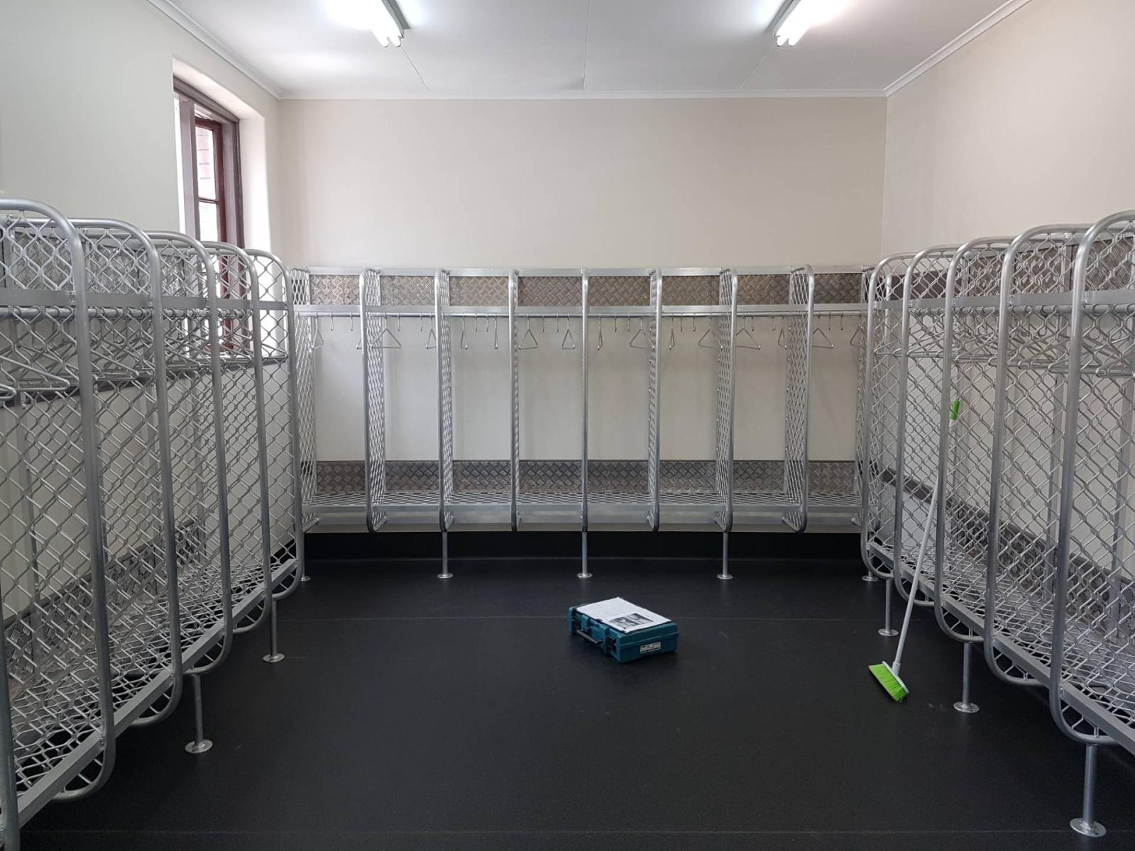 An empty locker room with a broom and a box on the floor.