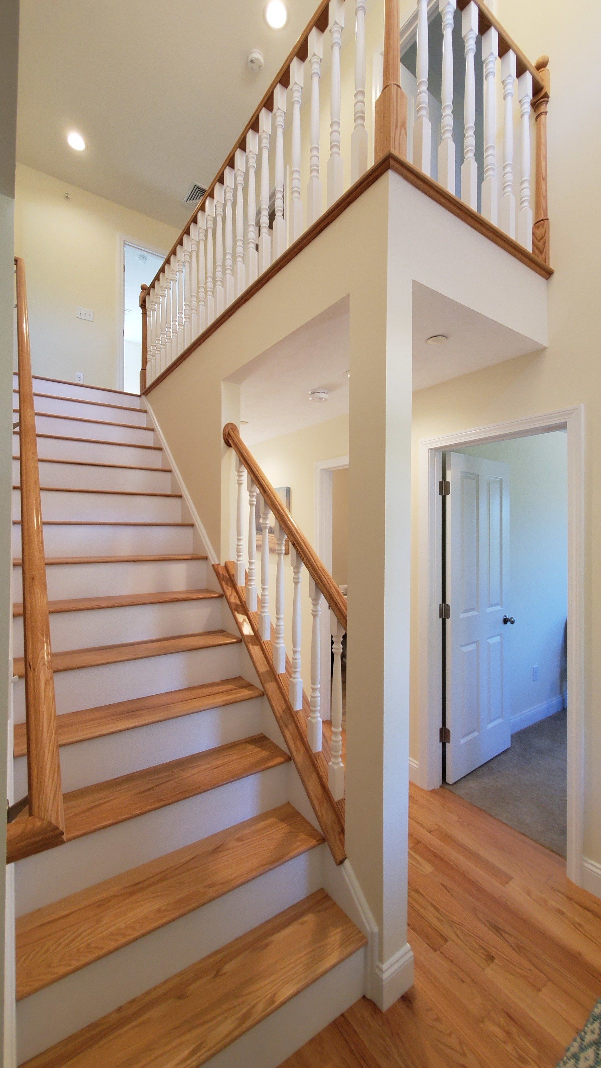 A staircase with wooden steps and a white railing in a house.