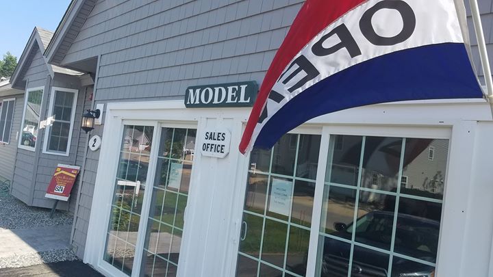 A model home with a red white and blue flag in front of it