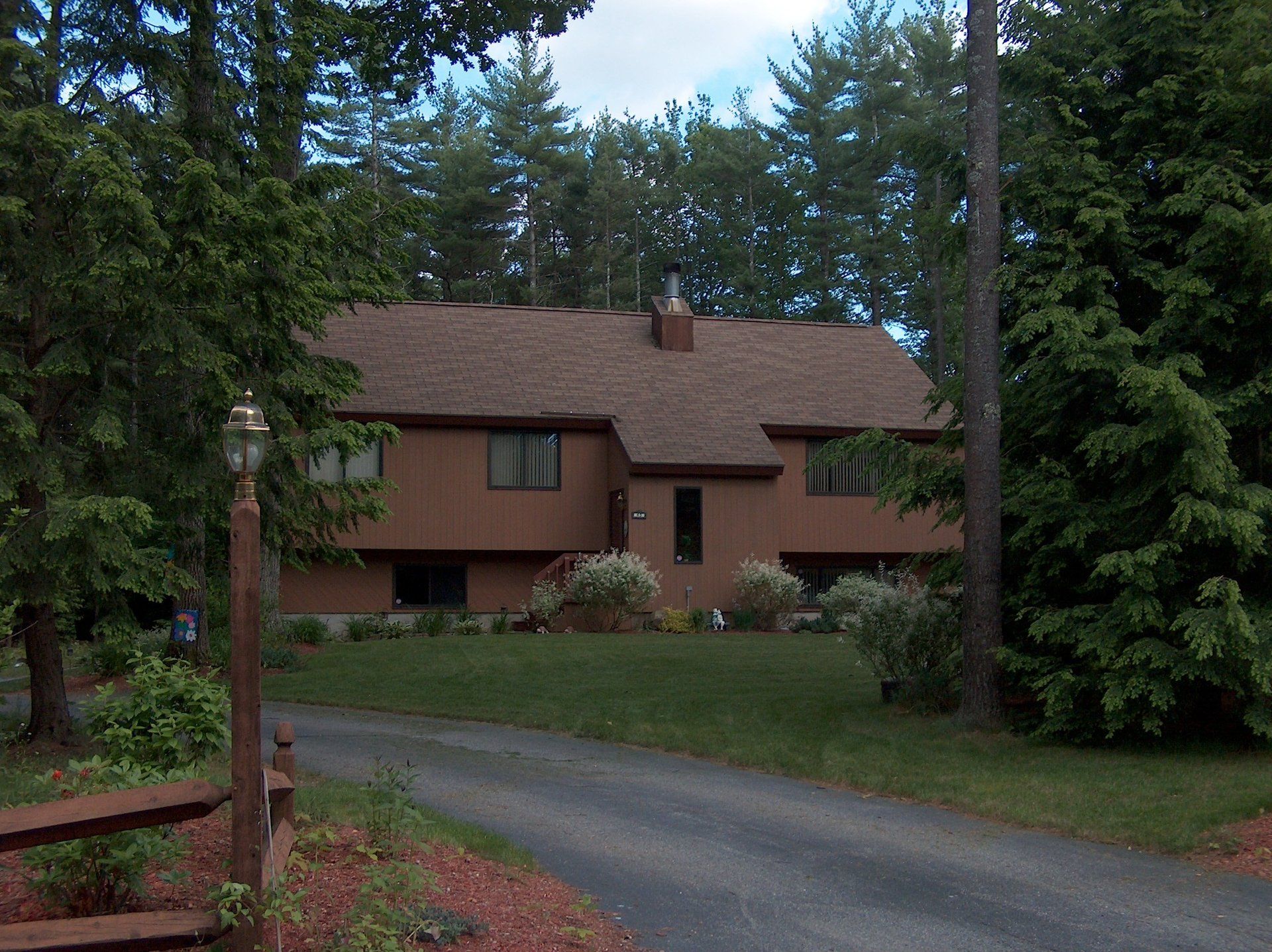 A house with a brown roof is surrounded by trees