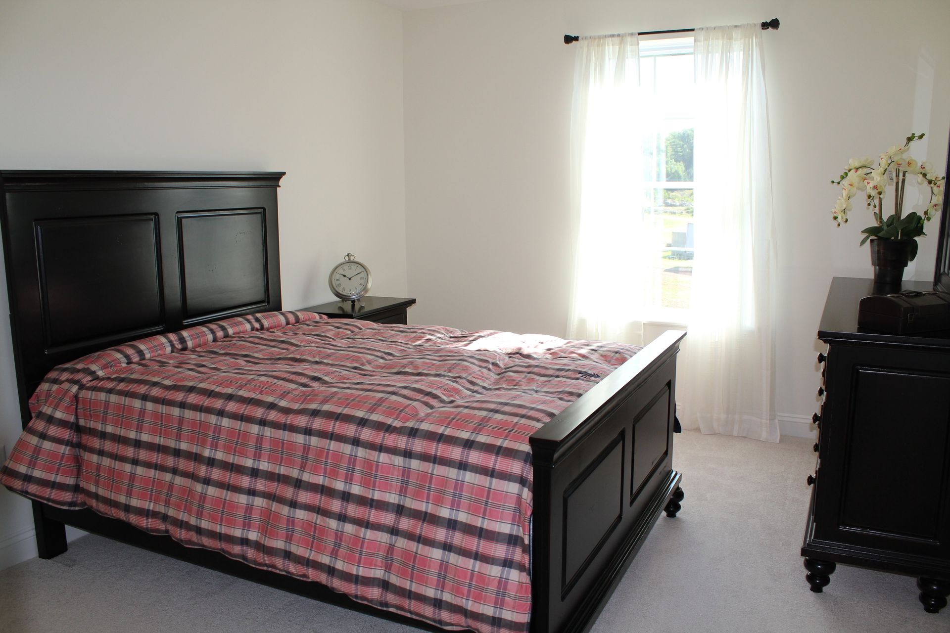 A bedroom with a bed , dresser and window