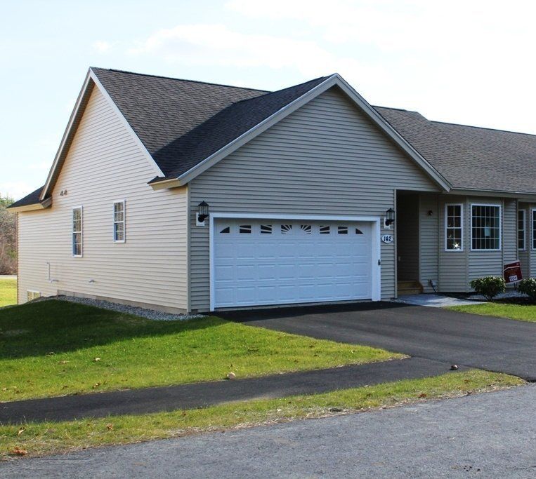A house with a white garage door and a gray roof