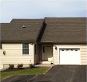 A house with a brown roof and a white garage door