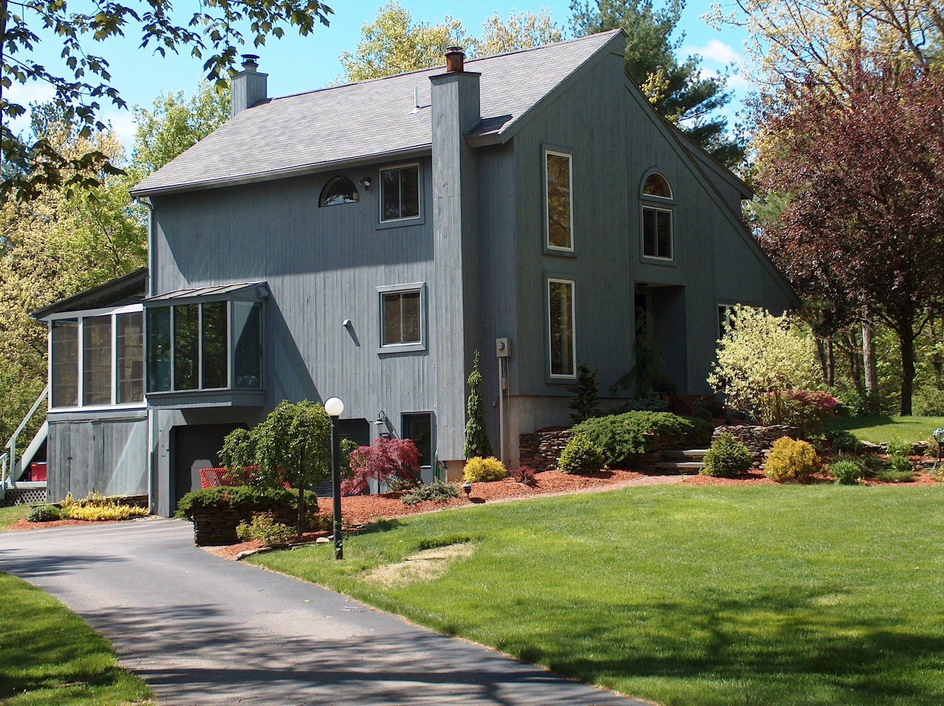 A large gray house with a driveway leading to it
