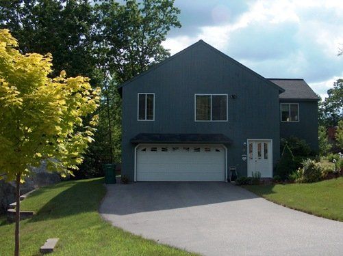 A large blue house with a white garage door