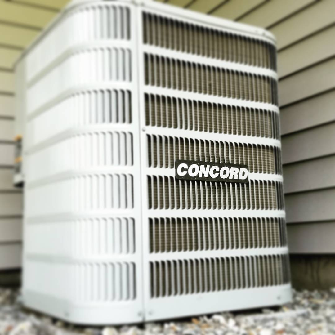 A concord air conditioner sits outside of a house