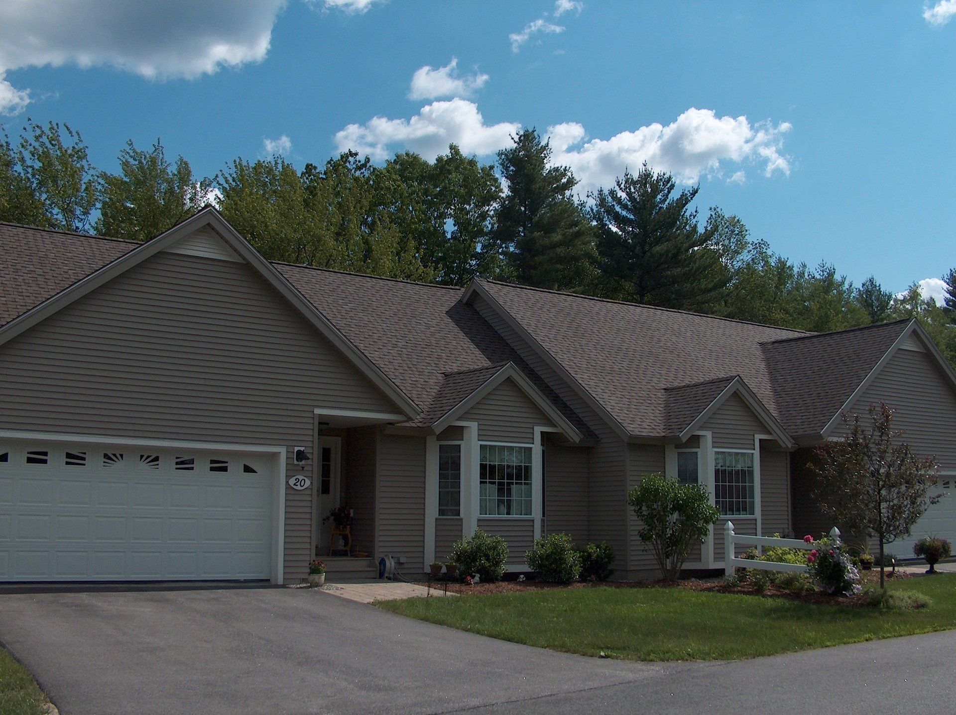 A house with a brown roof and a white garage door