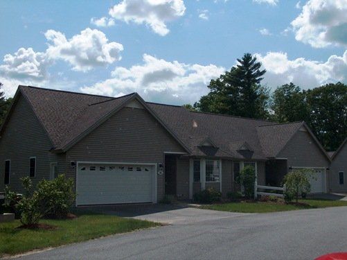 A house with a white garage door and a gray roof