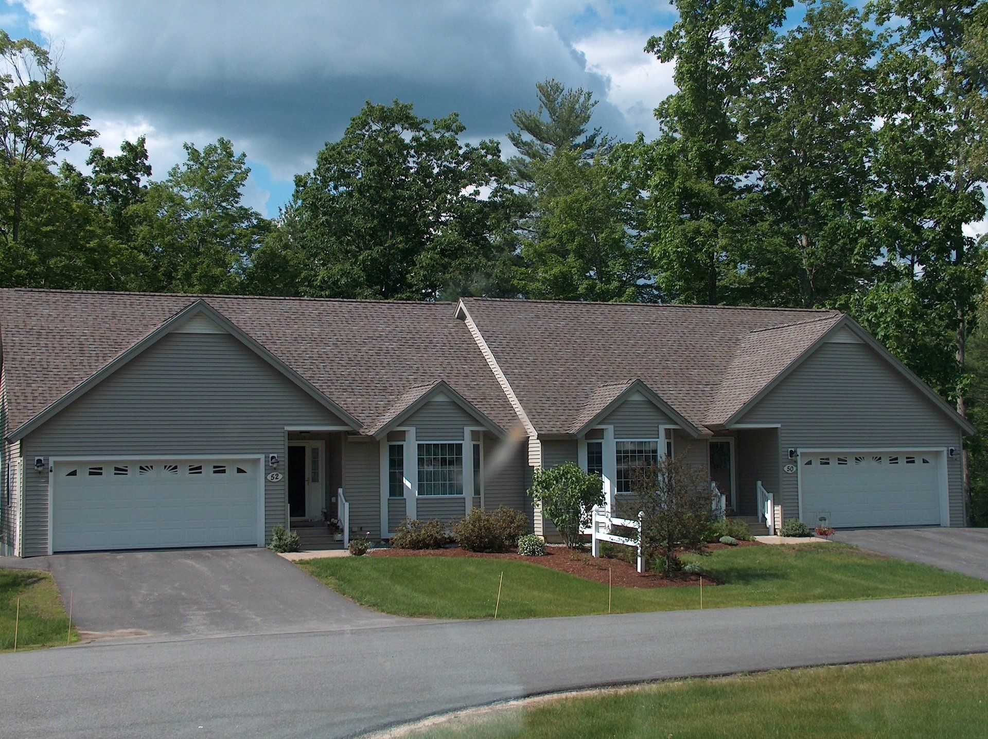 A house with a gray roof and white garage doors