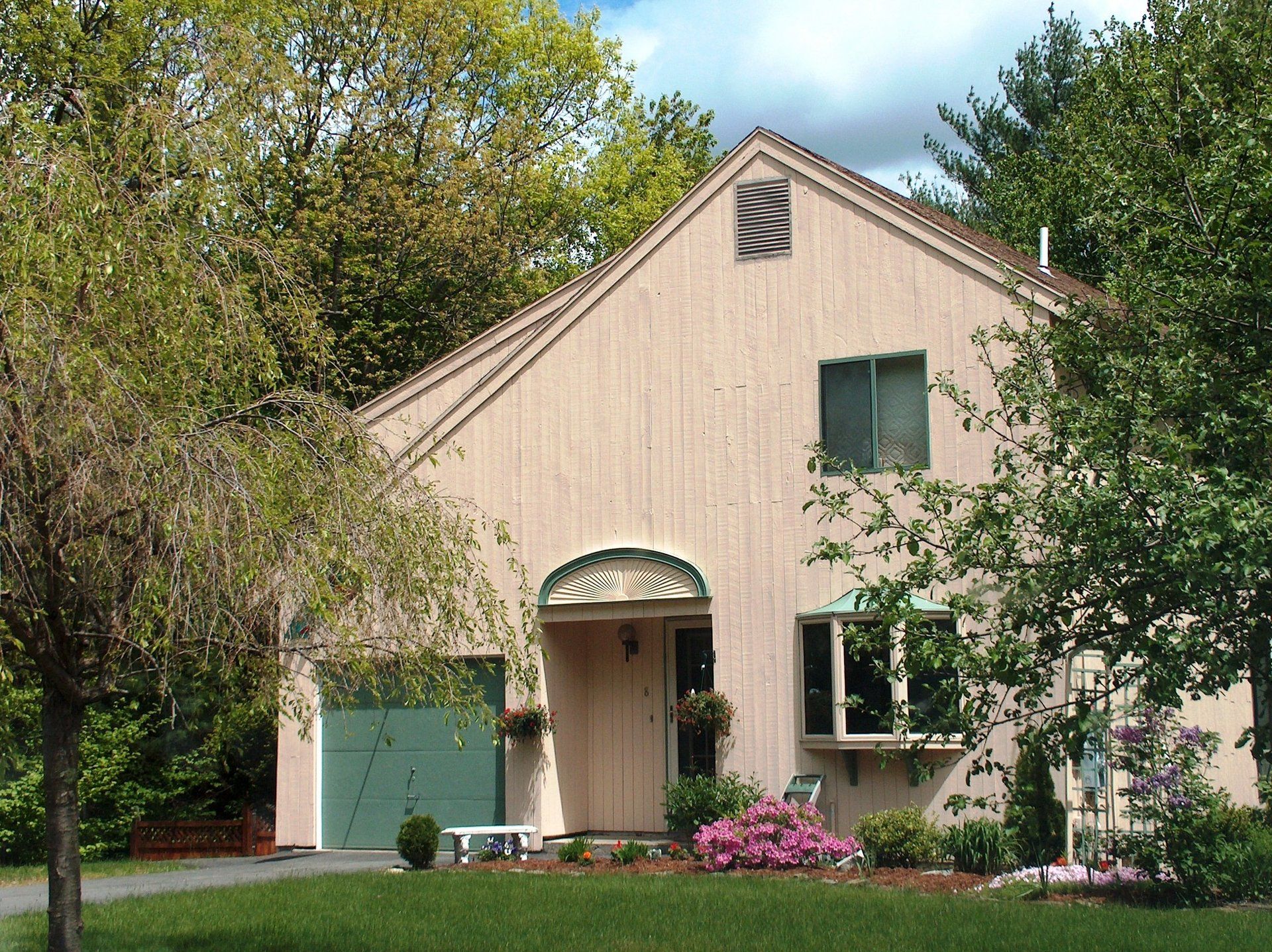 A house with a green garage and a roof that has the letter z on it