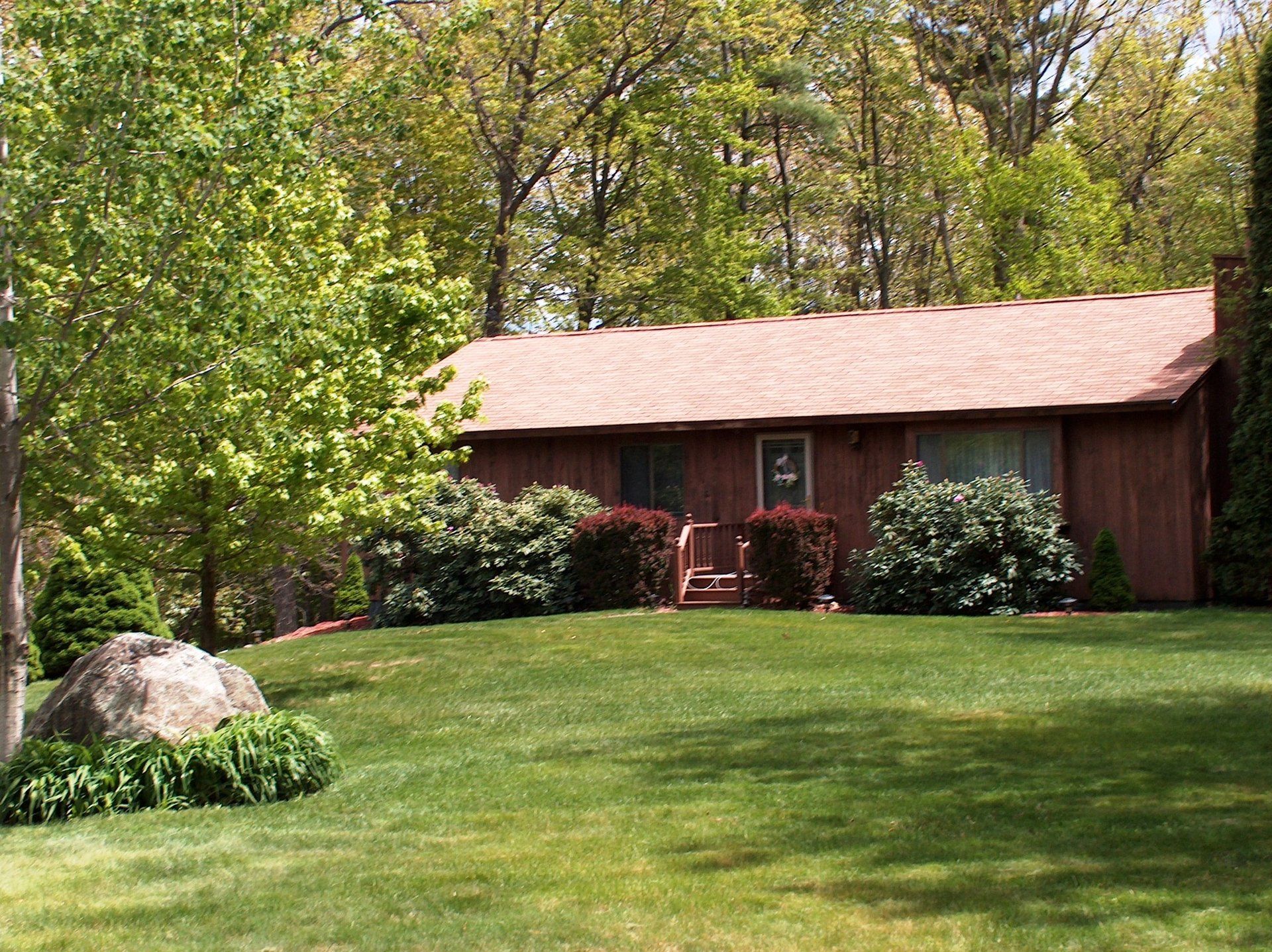 A house with a lush green lawn in front of it